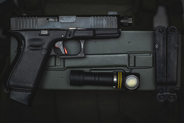 Tactical equipment and weapons, pistol with threaded barrel for suppressor, flashlight and multitool.