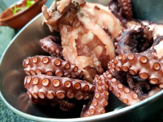 Fresh octopus in a bowl on the table. Close up. © kos1976