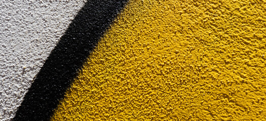Abstract wall surface with part of graffiti. Geometric lines yellow, black, white colors background