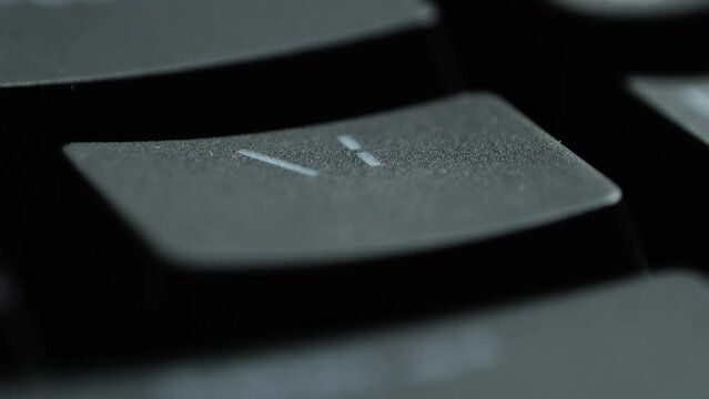 Keyboard button BACKSLASH. Macro shot of finger pressing BACKSLASH button