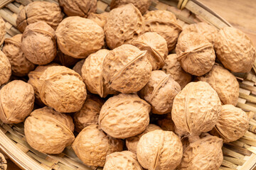 Walnuts kernels in wooden basket on wooden table.