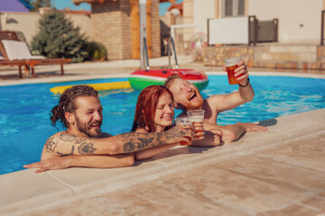 Friends drinking beer at the swimming pool