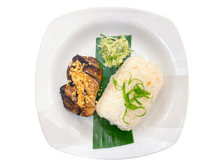Grilled piece of tuna with rice and vegetable salad on a banana leaf on a white plate isolated on a white background