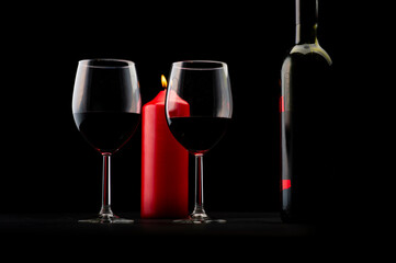Red wine bottle, two glass of wine and candle