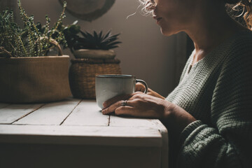 Sad woman cut out portrait with cup of herbal tea or coffee and thoughtful sad expression at home in boring indoor leisure activity, Concept of mental disease distraught and depression adult people