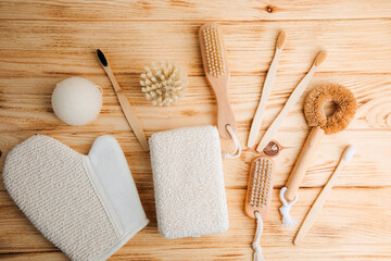 Set of brushes with wooden handles and washcloths on a wooden background, eco friendly products....