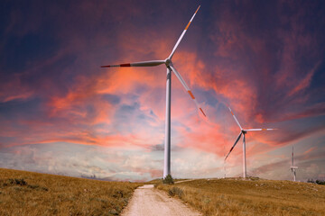 Scenery mountain in winter with a wind farm at sunset Wind turbines for green economy and...