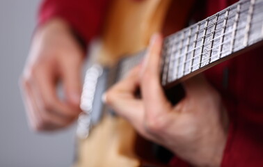 Man playing musical instrument guitar closeup. School of music concept - obrazy, fototapety, plakaty