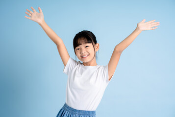 Portrait of Asian girl posing on blue background - obrazy, fototapety, plakaty