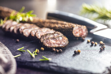 Smoked dried sausage. Sliced sausage on cutting board.