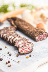 Smoked dried sausage. Sliced sausage on cutting board.