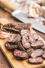 Smoked dried sausage. Sliced sausage on cutting board.