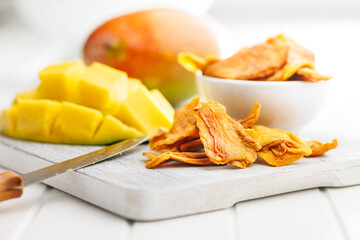Dried mango fruit on white table.
