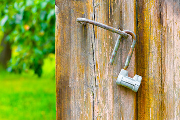 an old metal lock hanging on the doors of a barn in the garden