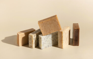 Natural herbal beige and brown soap bars on light beige close up, hard shadows