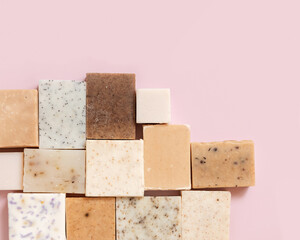 Beige and brown handmade soap bars on light pink top view. Natural herbal product for SPA
