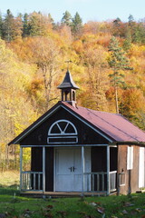 Mały drewniany kościółek w jesiennym lesie - obrazy, fototapety, plakaty