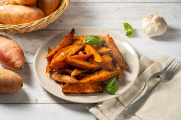 Delicious homemade sweet potato wedges, fries on a plate.