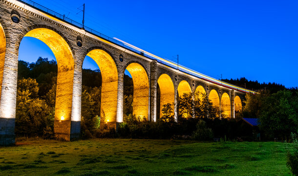 Panoramic view of &ldquo;Bekeviadukt&ldquo; bridge in Altenbeken Germany (1853). Historic railway viaduct on the main line Paderborn Warburg is a monument. Illumination at blue hour twilight from below the bridge