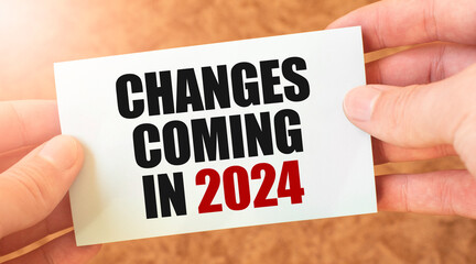 changes coming in 2024 word inscription on white card paper sheet in hands of a businessman.