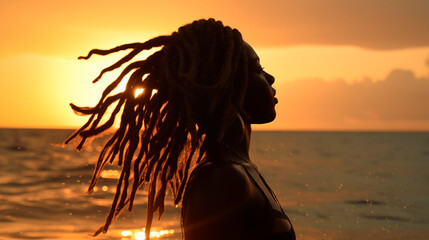 African-American woman with dreadlocks swims in the sea at sunset. Backlighting. A woman with dark skin. Vacation at sea, summer. Splashes of water
