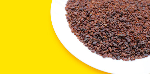Black himalayan salt on yellow background.