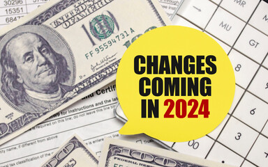 changes coming in 2024  on yellow sticker with pen and calculator - Powered by Adobe