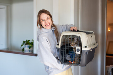 A young female student holding cat in carrier.