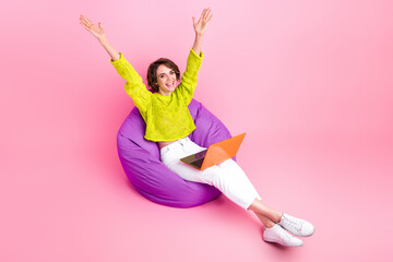 Full length photo of pretty excited girl dressed neon sweater sitting bean bag online studying...