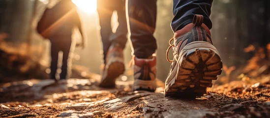 Foto auf Acrylglas Straße im Wald Hiker group walking in forest in sunset light. shoe rear view.  