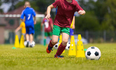 School children in Blue and Red Soccer Team in Training Slalom Drill. Kids Playing Football Ball on...