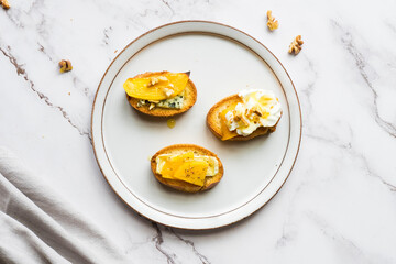 Baguette slices with cream cheese, persimmon, honey, and nuts
