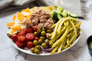 Nicoise Salad - French style salad with eggs, tuna, tomatoes, green olives, potatoes, green beans and cucumber