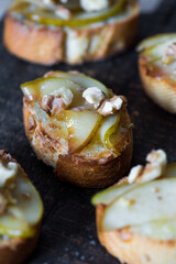 Appetizer bruschetta with pear, honey, walnut and blue cheese