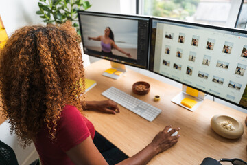 Creative agency employee retouching digital photos while using computer mouse and display