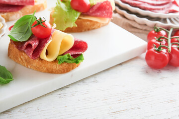 Salami sandwich. Delicious toasted sandwiches with slice salami, cheddar cheese lettuce and tomatoes cherry on white marble background. Restaurant menu, cafe, recipe or article concept. Mock up.