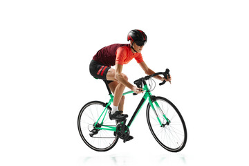 Muscular young man, athlete, cyclist in uniform and helmet, riding bicycle isolated over white studio background