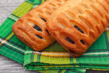 Fresh baked puff pastry pies with jam on green towel. Selective focus. - 692505586