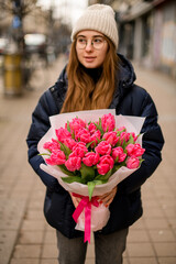 Young beautiful girl with a bouquet of tulips in her hands
