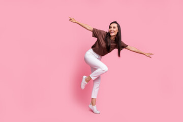 Full size photo of cheerful gorgeous girl hands wings dancing chilling empty space isolated on pink color background