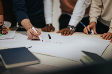 Multiracial business team in a late-night office, collaborating on project development, analyzing reports, and discussing strategies for business growth and profitability.