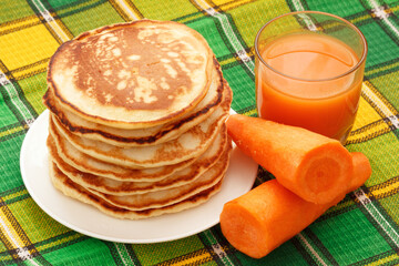 Homemade pancakes heap on plate with fresh carrot juice healthy lunch - 692511796