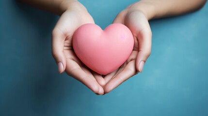 Obraz premium Knitted heart holding a woman's hands close-up. Symbol of love. Happy Valentine's Day