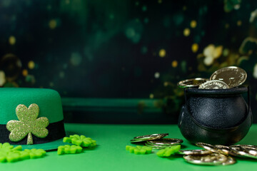 Black pot full of gold coins and leprechaun hat.