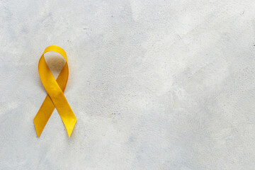 Yellow ribbon symbol of bone cancer and suicide problems awareness concept