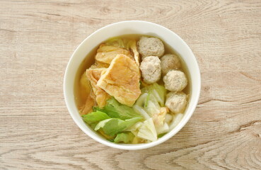 fried slice Thai egg omelet with cabbage in clear soup on bowl