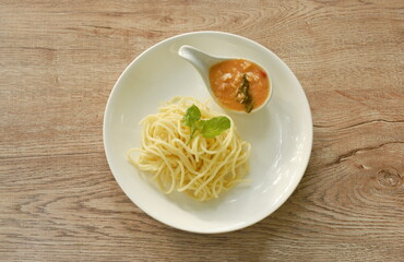 boiled spaghetti dressing spicy fried chop chicken with chili and basil sauce on plate  
