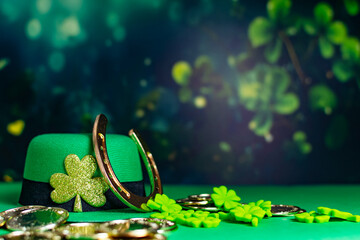 Happy St Patrick Day leprechaun hat with gold coins and lucky charms on green background.
