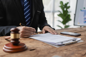 Close up of a businessman lawyer working with a hammer and a judge's scale for a lawyer consulting...