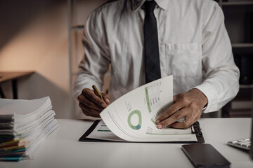 Black businessman planning paperwork and financial reports at desktop computer, young entrepreneur...